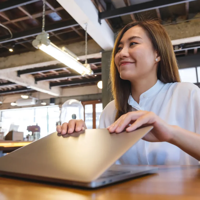 Kobieta pracująca przy laptopie, przymyka laptopa