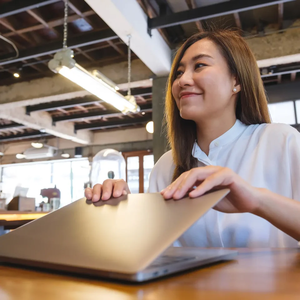 Kobieta pracująca przy laptopie, przymyka laptopa